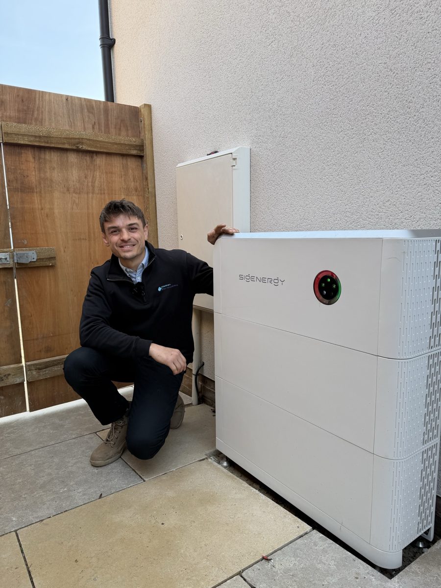 Jamie from Welton Renewables next to an installed battery